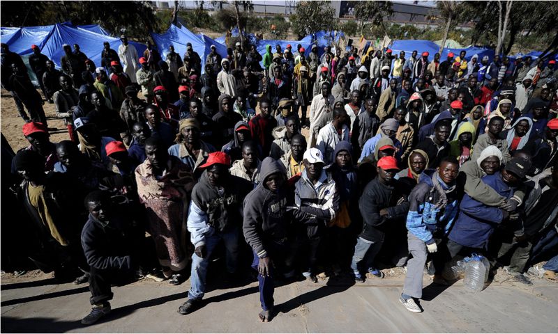 African immigrants stranded in Libya stand near makeshift tents outside the port of the Libyan city of Misrata on March 31, 2011.[Getty Images]