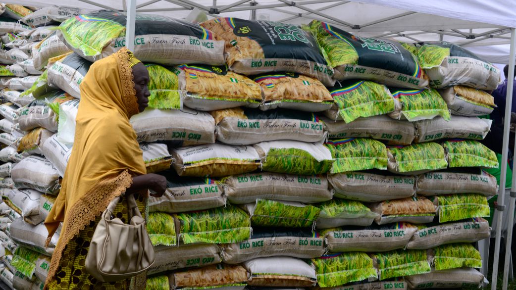 A woman walks past a stand loaded with Eko Rice