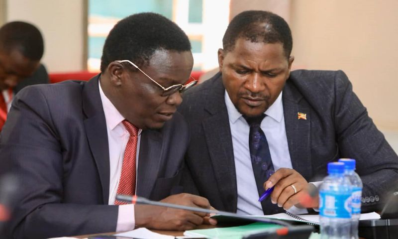 Jonathan Odur (L) peruses a document with David Zijjan, Butembe County MP