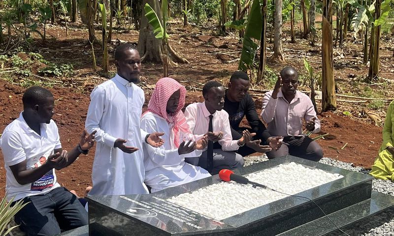 Alex Luswa Luwemba praying at the grave of Muhammad Ssegirimya