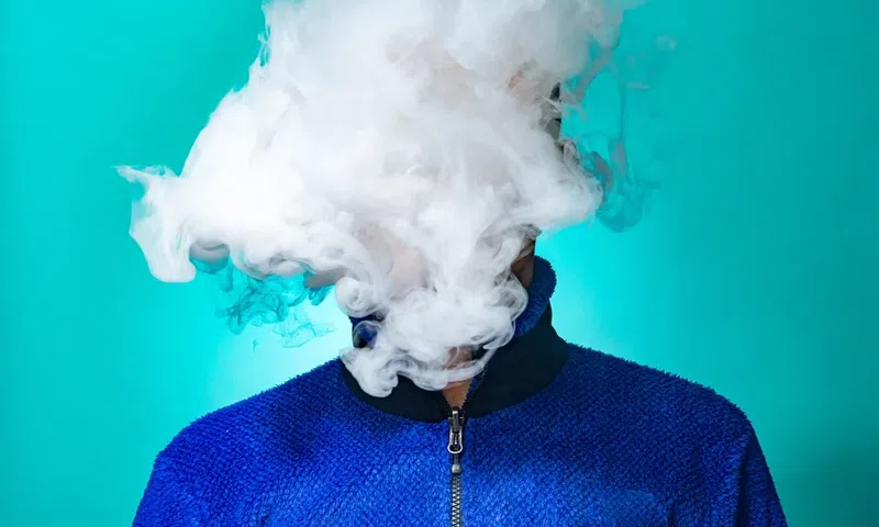 A person with a cloud of smoke on their face