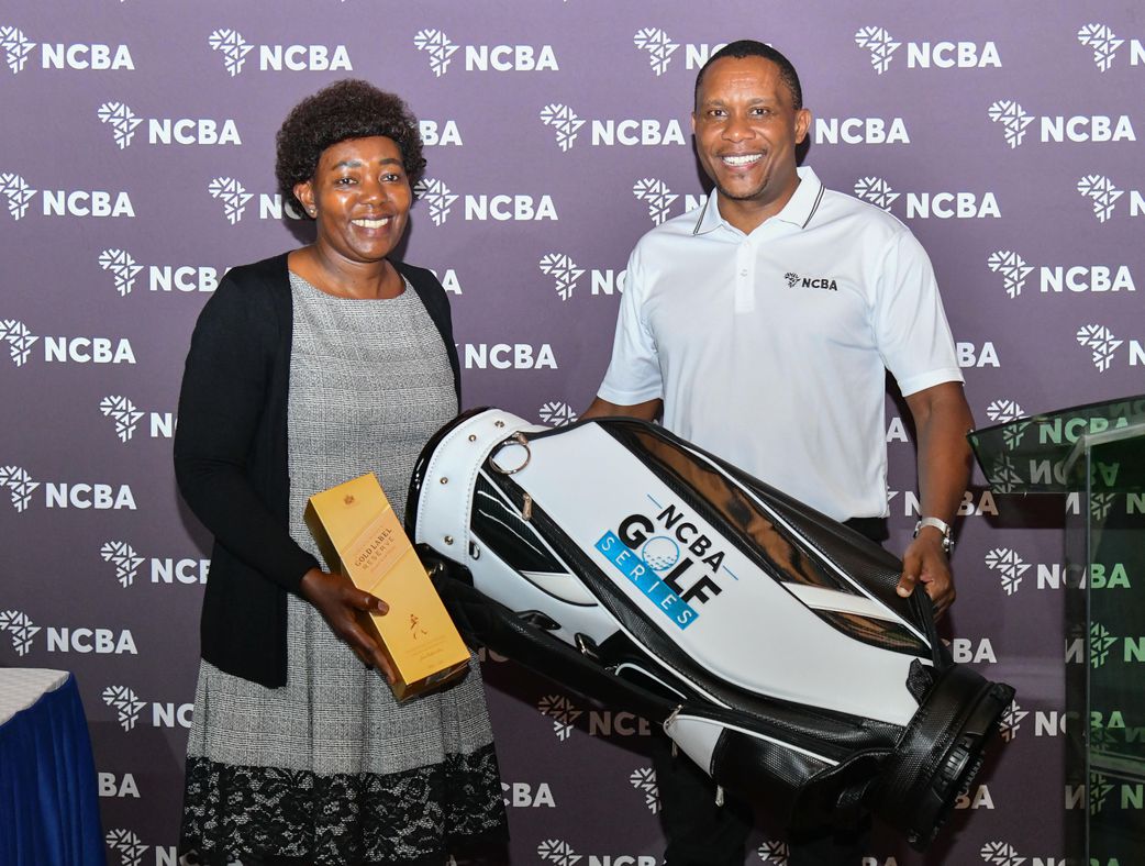 Naomi Kimata (left) receives her award from NCBA Thika Branch Manager Nicholas Njenga after emerging as the overall ladies winner at the NCBA Golf Series tournament held at Thika Sports Club