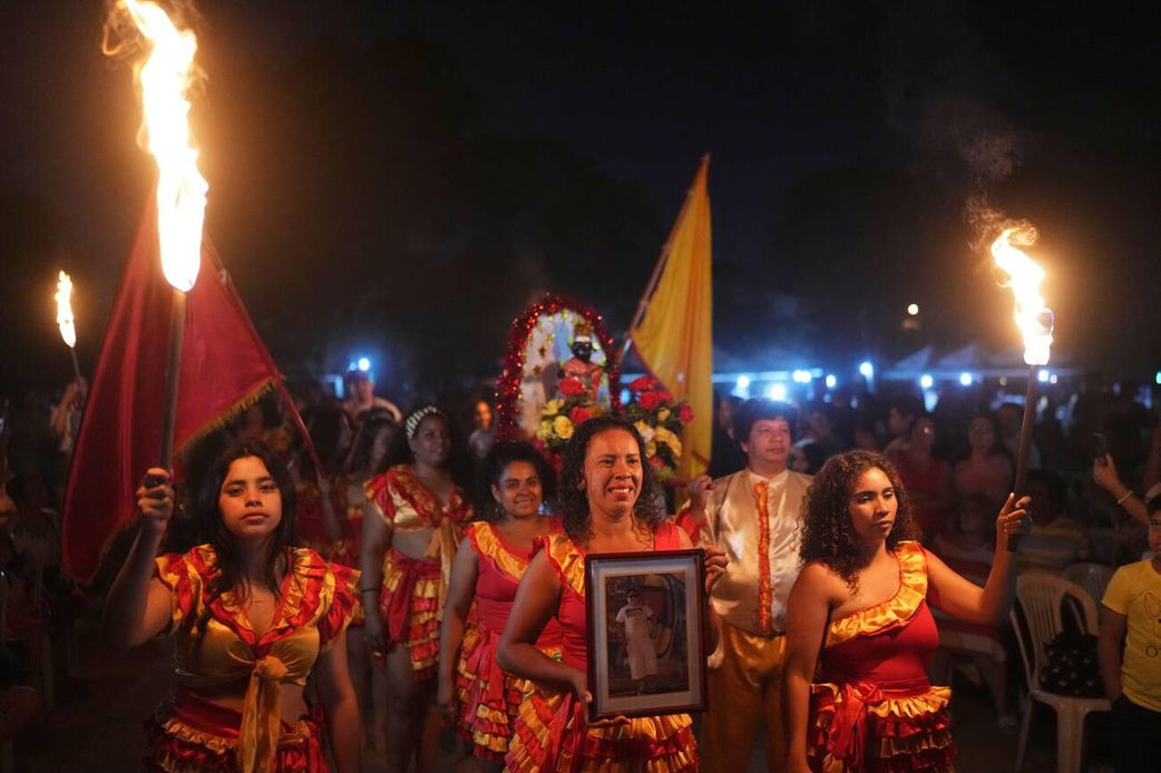 Members of the Paraguay-African cultural group Kamba Cua dance during celebrations in honor of Saint Balthazar, one of the Three Kings, on Epiphany in Fernando de la Mora, Paraguay, just after midnight Sunday, January 9, 2022.