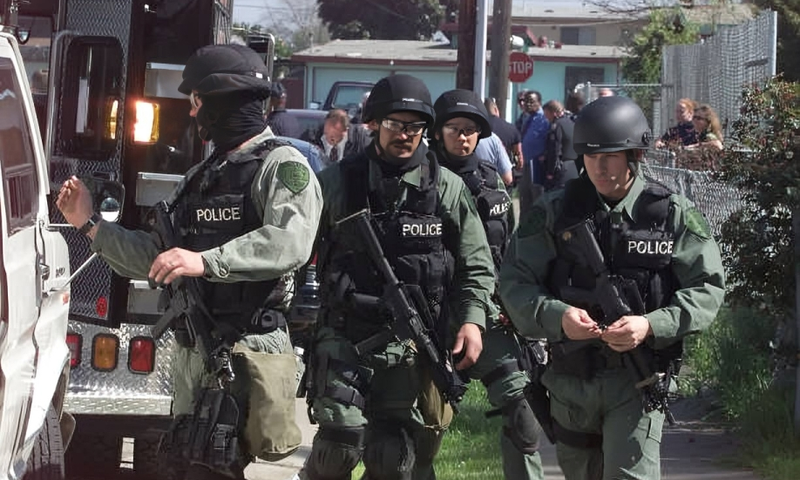 A SWAT team prepares to surround a home in East Palo Alto, where a man was believed to be barricaded inside the home with weapons and potential hostages on Wednesday, March 14, 2001.