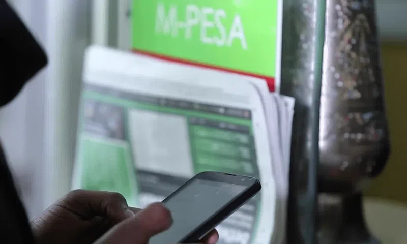 A person using MPESA to pay for services