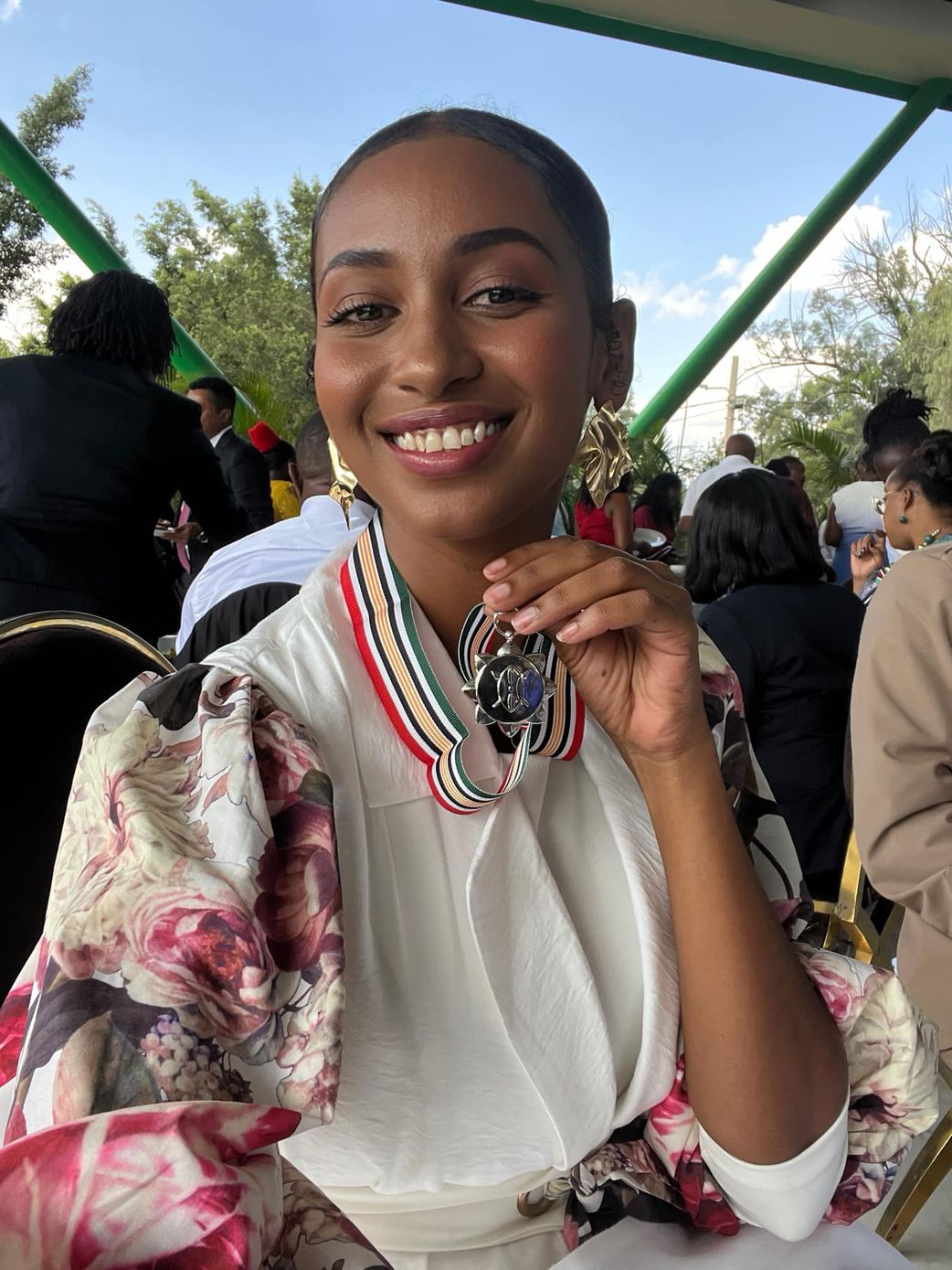 Sarah Hassan shows off her OGW medal awarded py President William Ruto during a luncheon at State House, Nairobi
