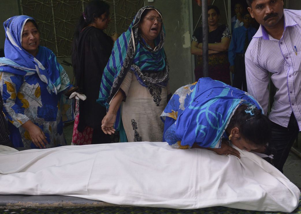 Relatives of convicted murderer Aftab Bahadur mourn beside his body after his execution in Lahore, Pakistan,