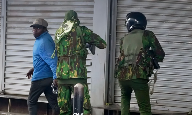 Police officers confront city hawker in Nairobi during protests