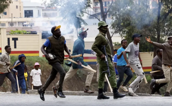 Armed goons pictured walking alongside the police in the streets of Nairobi during protests in Nairobi earlier this week