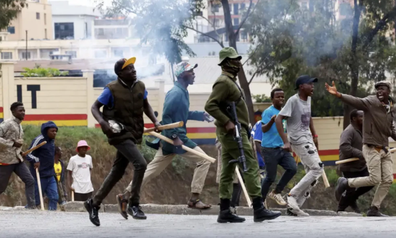 Armed goons pictured walking alongside the police in the streets of Nairobi during protests in Nairobi earlier this week
