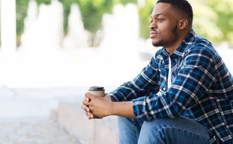 A black man seated thinking