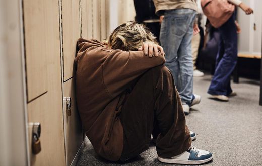 Picture of a girl crouched down in a school corridor.Maskot/Getty Images