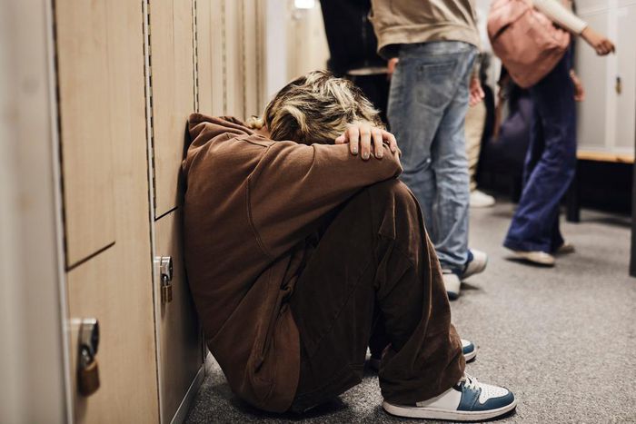 Picture of a girl crouched down in a school corridor.Maskot/Getty Images