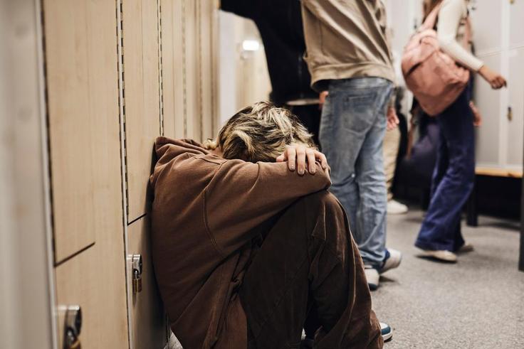 Picture of a girl crouched down in a school corridor.Maskot/Getty Images