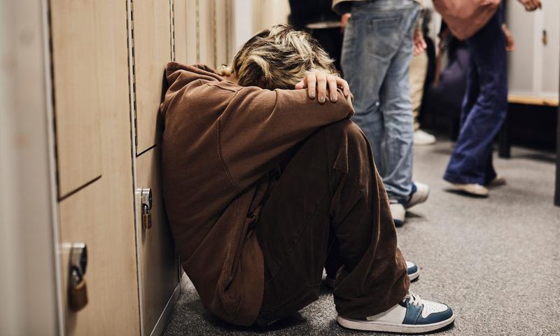 Picture of a girl crouched down in a school corridor.Maskot/Getty Images
