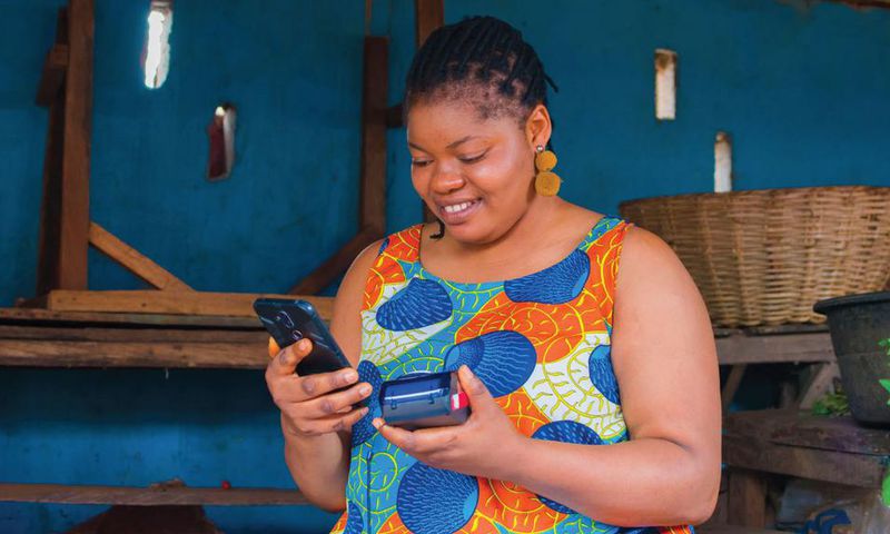 Une femme entrepreneure utilisant un appareil de paiement numérique