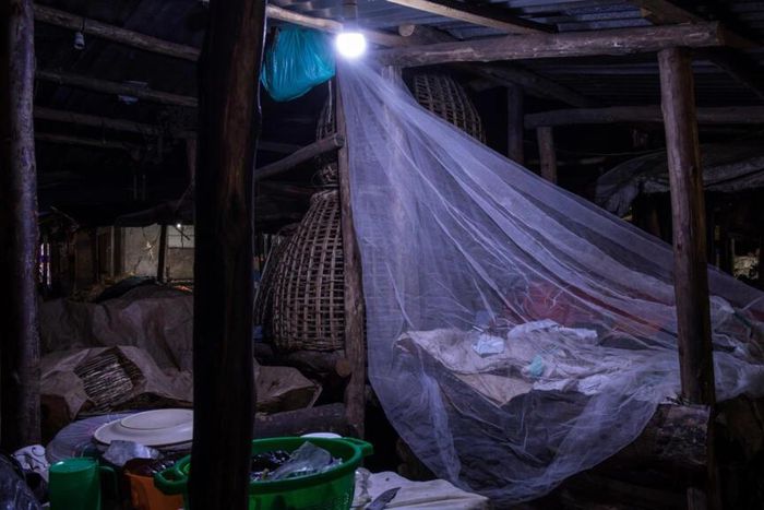 Un vendeur dort sur le marché de Kamapala, dans une moustiquaire afin de se protégéer des moustiques vecteurs du paludisme, le 3 avril 2020 Badru KATUMBA AFP/Archives
