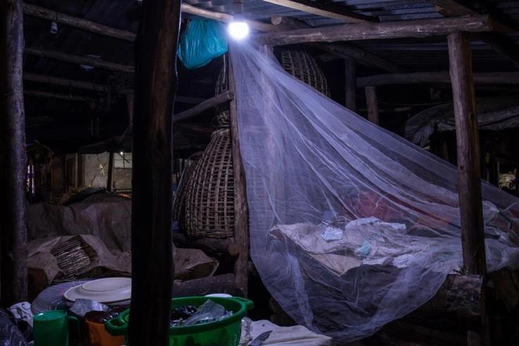 Un vendeur dort sur le marché de Kamapala, dans une moustiquaire afin de se protégéer des moustiques vecteurs du paludisme, le 3 avril 2020 Badru KATUMBA AFP/Archives