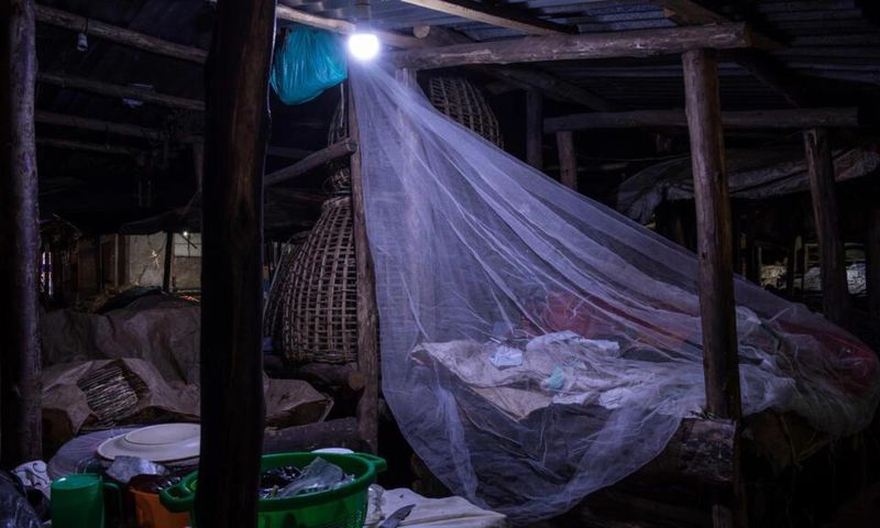 Un vendeur dort sur le marché de Kamapala, dans une moustiquaire afin de se protégéer des moustiques vecteurs du paludisme, le 3 avril 2020 Badru KATUMBA AFP/Archives