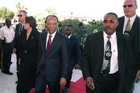 Le président Jean-Bertrand Aristide, sa femme Mildred Trouillot et des gardes du corps, le 7 avril 2003, lorsqu’il a demandé des réparations à la France/Thony Belizaire/Agence France-Presse — Getty Images