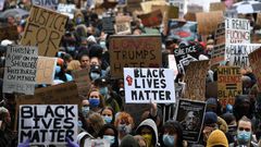 Protesters hold placards as they attend a demonstration in Parliament Square in central London on June 6, 2020, to show solidarity with the Black Lives Matter movement in the wake of the killing of George Floyd, an unarmed black man who died after a po...