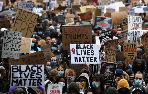 Protesters hold placards as they attend a demonstration in Parliament Square in central London on June 6, 2020, to show solidarity with the Black Lives Matter movement in the wake of the killing of George Floyd, an unarmed black man who died after a po...