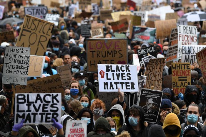 Protesters hold placards as they attend a demonstration in Parliament Square in central London on June 6, 2020, to show solidarity with the Black Lives Matter movement in the wake of the killing of George Floyd, an unarmed black man who died after a po...