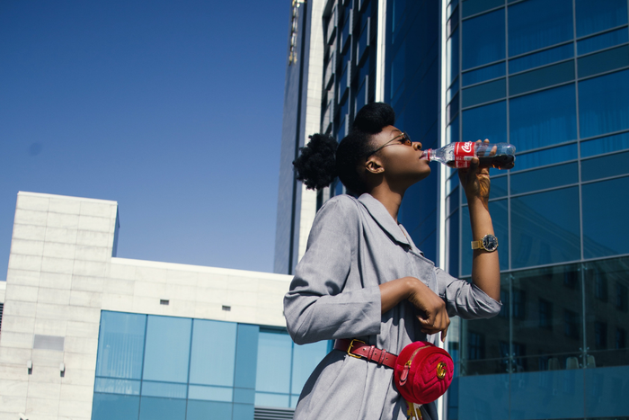 Une femme noire buvant Coca Cola