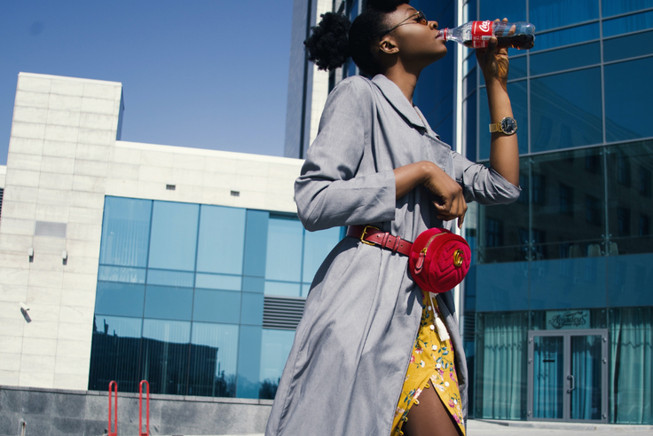 Une femme noire buvant Coca Cola