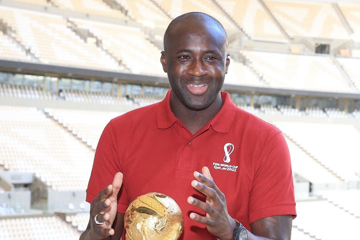 Le footballeur Yaya Touré en face du trophée de la Coupe du monde de Football Qatar 2022