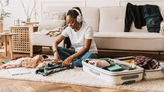 Une jeune femme qui prépare ces affaires de voyage.