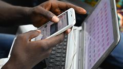 Un jeune manipulant son téléphone/Le Monde