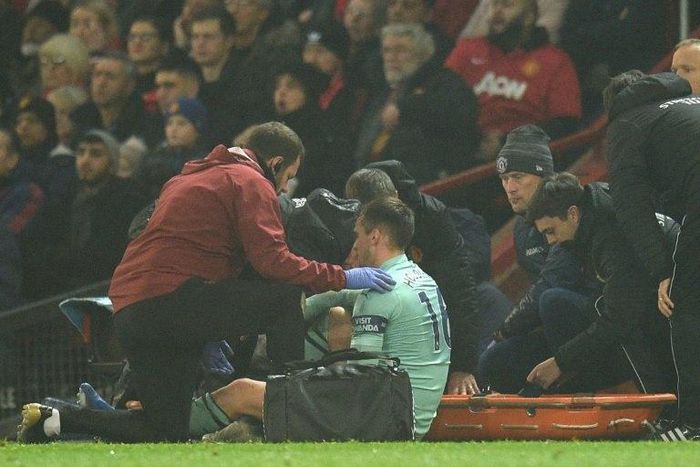 Arsenal defender Rob Holding receives medical attention at Old Trafford