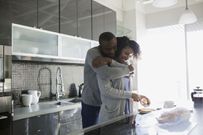 A happy couple in their kitchen, cooking.