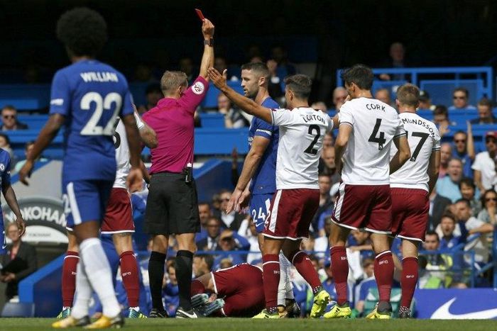 Chelsea's Gary Cahill (C) is shown a red card by referee Craig Pawson after a foul on Burnley's Steven Defour during their English Premier League match, at Stamford Bridge in London, on August 12, 2017
