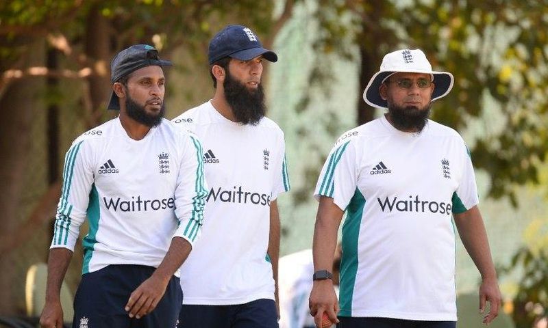England players Adil Rashid (L) and Moeen Ali head for a training session with bowling coach Saqlain Mushtaq (R)
