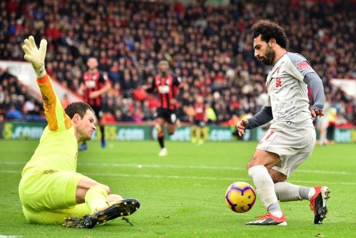 Liverpool's Egyptian midfielder Mohamed Salah (R) takes the ball around Bournemouth's Bosnian-Herzegovinian goalkeeper Asmir Begovic (L0 in the build-up to scoring his third goal, Liverpool's fourth during the English Premier League football match betw...