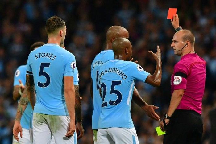 Manchester City's defender Kyle Walker is shown the red card by referee Robert Madley (R) on August 21, 2017
