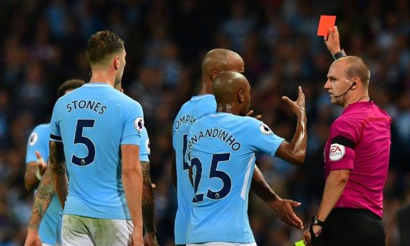 Manchester City's defender Kyle Walker is shown the red card by referee Robert Madley (R) on August 21, 2017