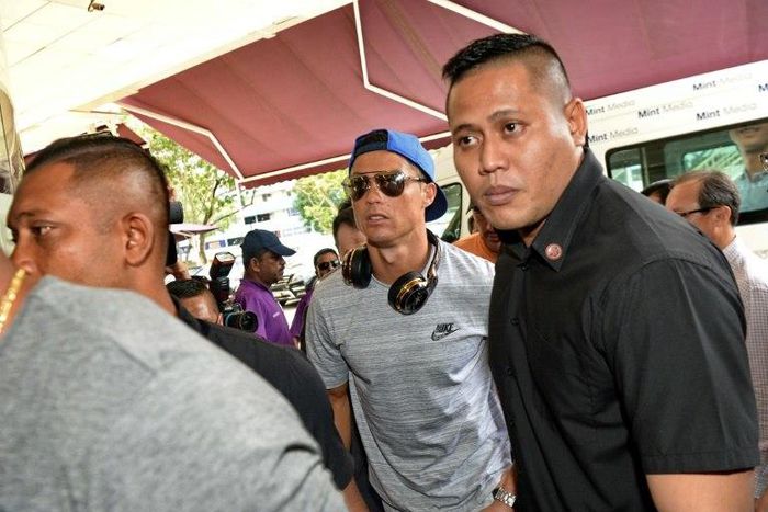 Cristiano Ronaldo (C) arrives at Thomson Medical Hospital to visit the daughter of Singaporean billionaire Peter Lim, on July 21, 2017