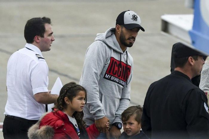 Barcelona player Luis Suarez (C) arrives with his family at the Santa Fe Province airport in Rosario, Argentina for his teammate Lionel Messi's wedding