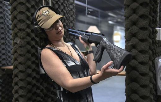 Brazilian lawyer Barbara Barroso proudly shows off her brand-new 12-gauge Armsan pump-action shotgun at the Colt 45 Shooting Club in Rio de Janeiro