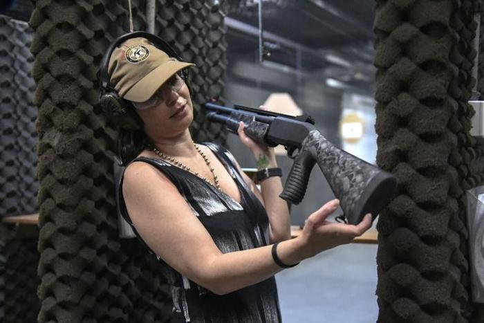 Brazilian lawyer Barbara Barroso proudly shows off her brand-new 12-gauge Armsan pump-action shotgun at the Colt 45 Shooting Club in Rio de Janeiro