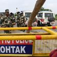 Indian security personnel stand guard along a road near Sonariya jail in Rohtak