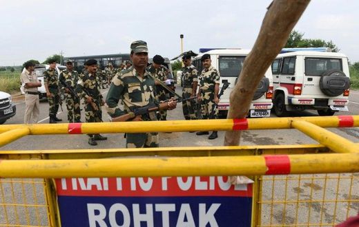 Indian security personnel stand guard along a road near Sonariya jail in Rohtak