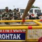 Indian security personnel stand guard along a road near Sonariya jail in Rohtak