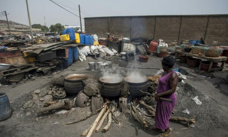Cauldrons pf the traditional sorghum-based pito drink bubble away in fire pits in Tema, Accra