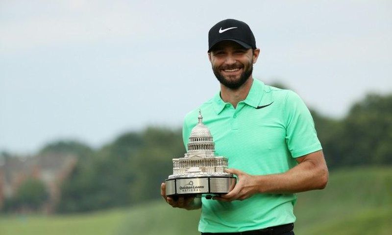 Kyle Stanley of the US celebrates with the winner's trophy after defeating compatriot Charles Howell in a playoff of the PGA National, in Potomac, Maryland, on July 2, 2017