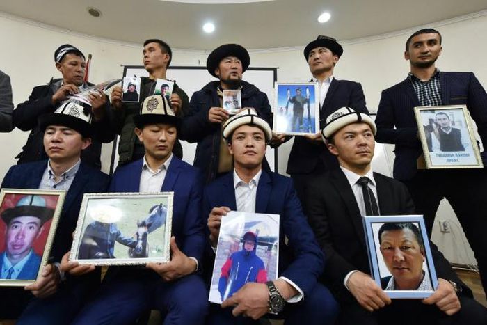 Kyrgyz family members hold portraits of their relatives who they fear are being held in notorious "re-education camps" in China's Xinjiang region