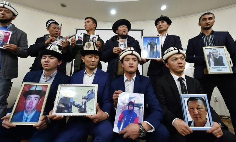 Kyrgyz family members hold portraits of their relatives who they fear are being held in notorious "re-education camps" in China's Xinjiang region